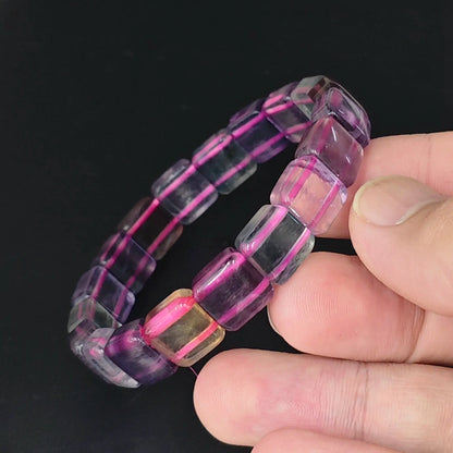 hand holding purple fluorite stretch bangle with 11mm square cube beads