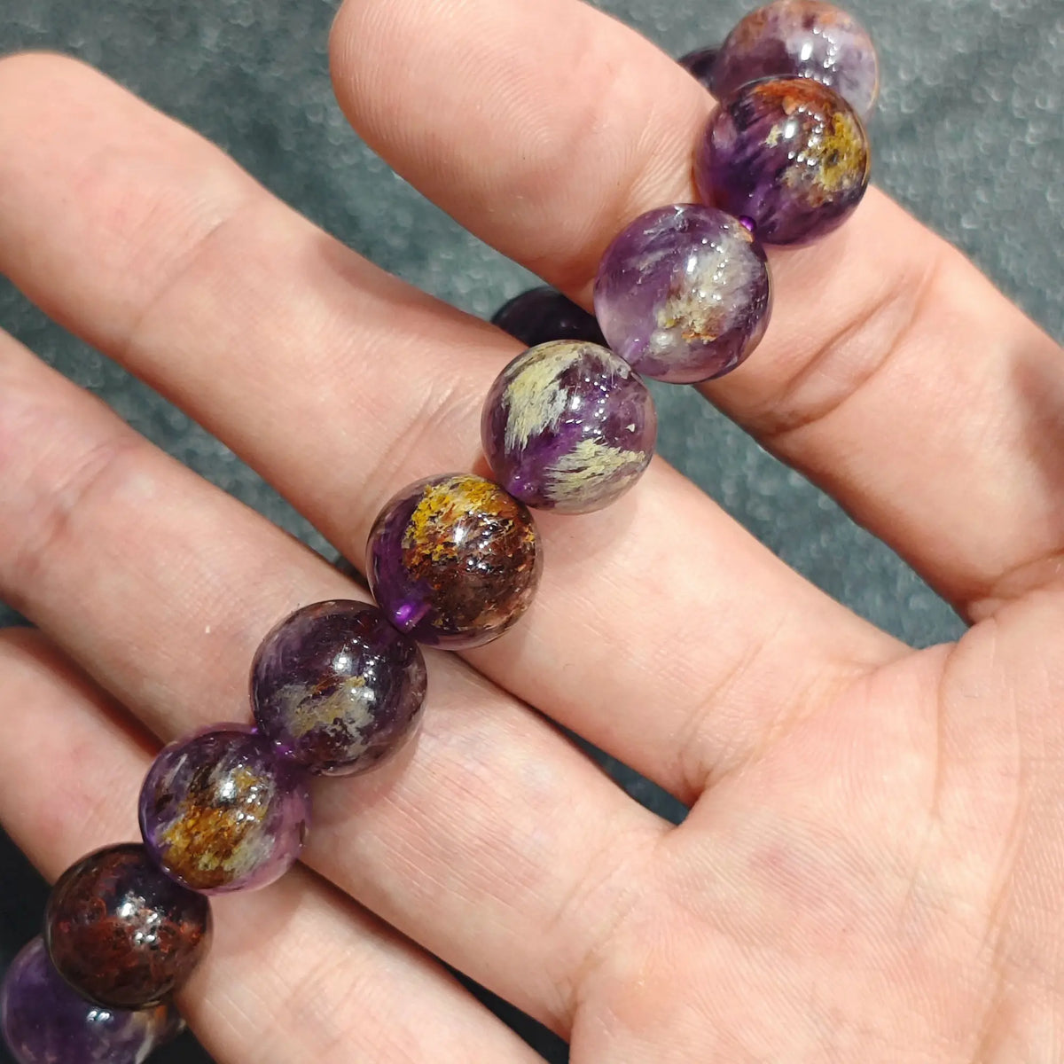 Straight alignment view of purple phantom quartz beads showcasing semi translucent body color under soft studio light
