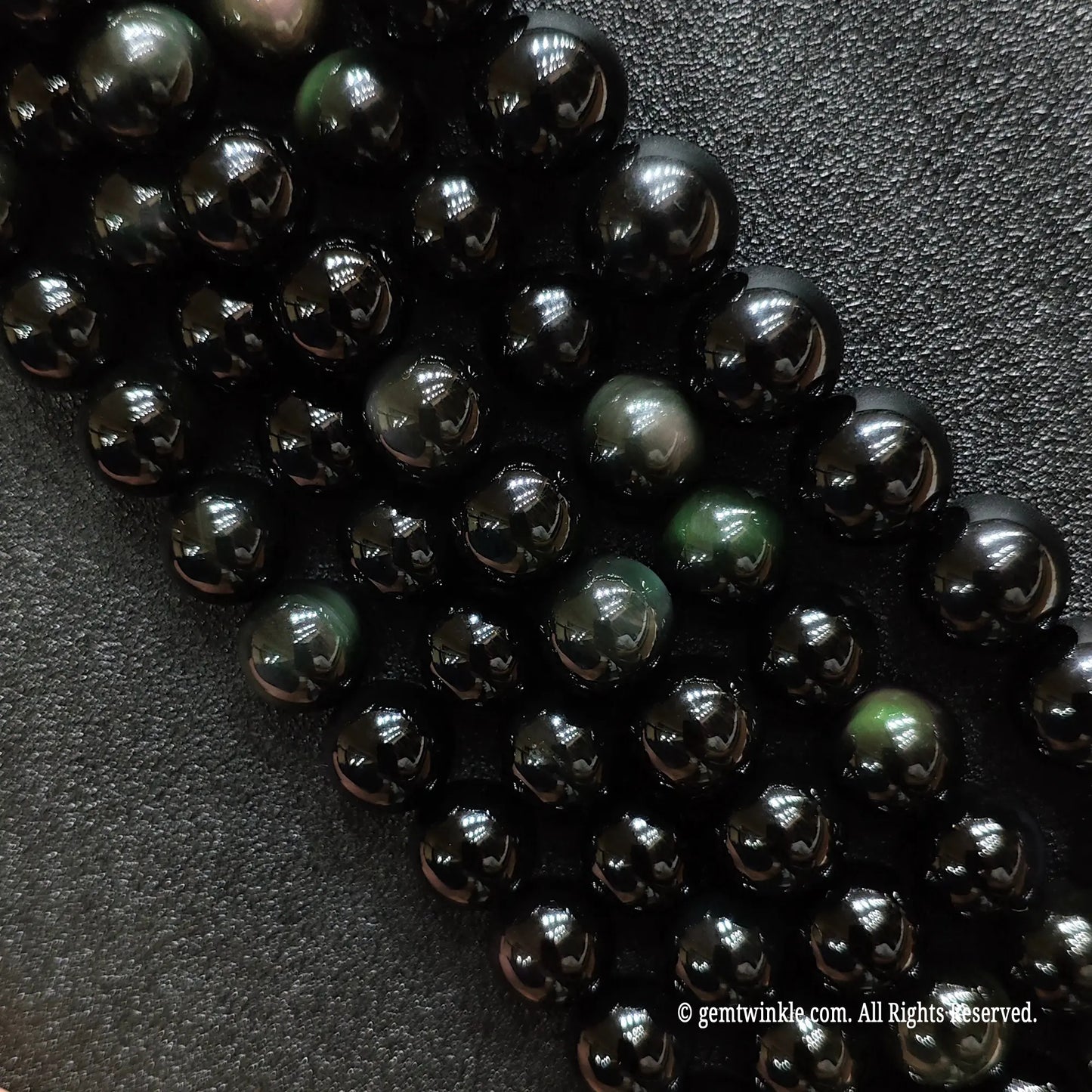Natural rainbow obsidian crystal beads strands showing rich purple and green dual-color flash under direct light