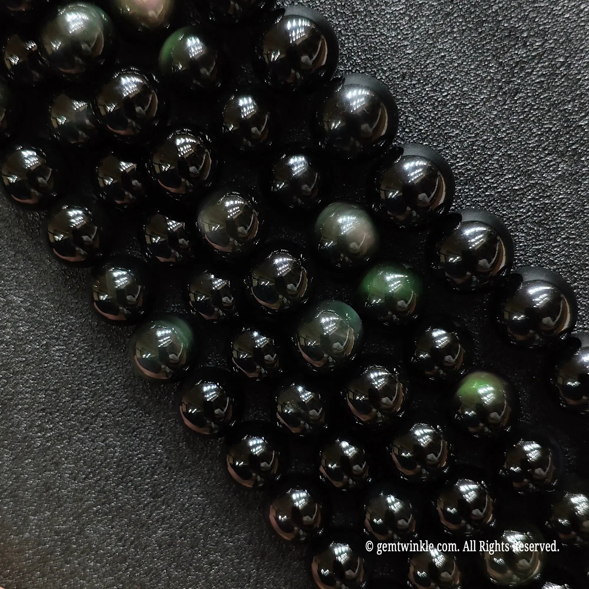 Natural rainbow obsidian crystal beads strands showing rich purple and green dual-color flash under direct light