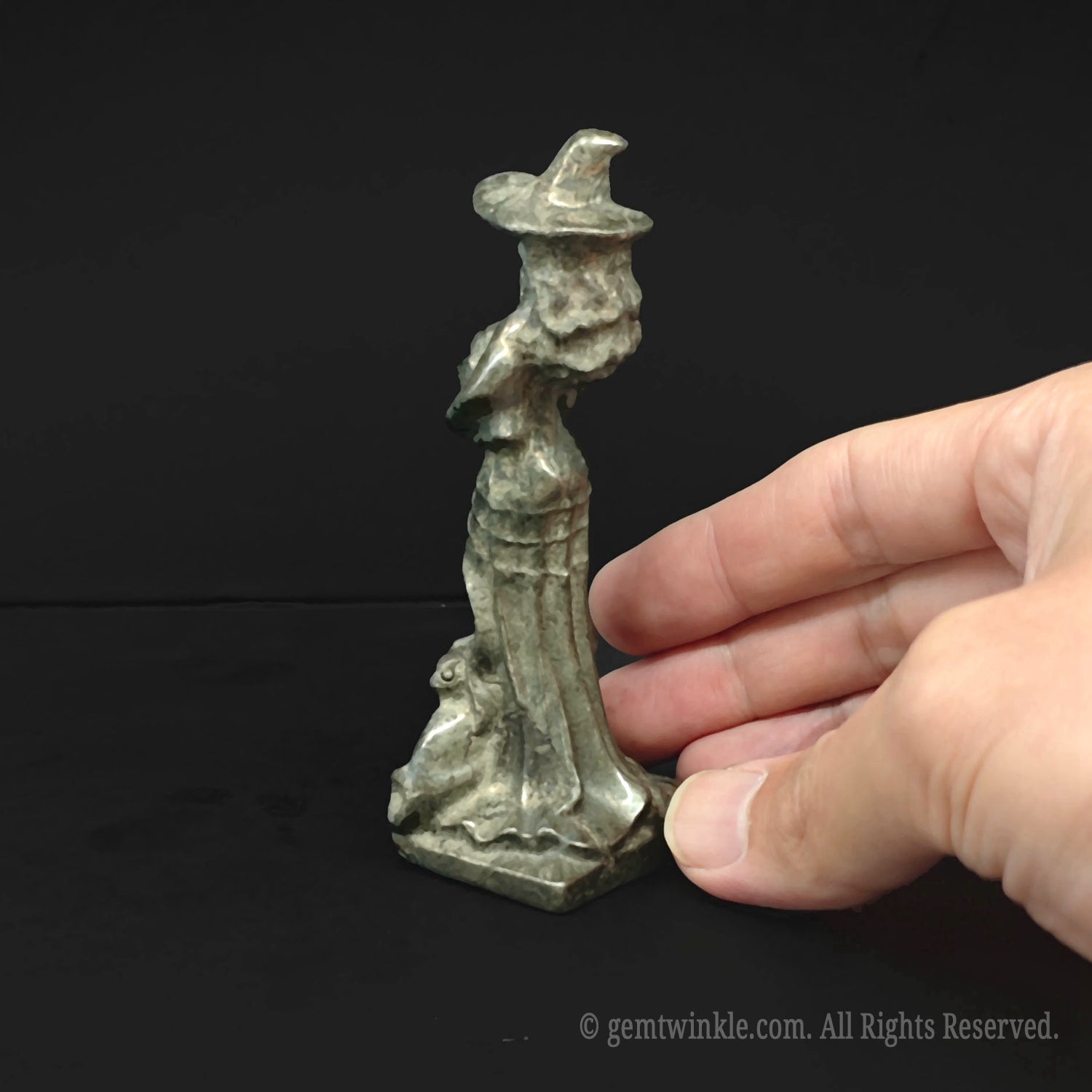 Back view of the hand sculpted metallic pyrite witch figurine highlighting flowing hair and detailed hat lines