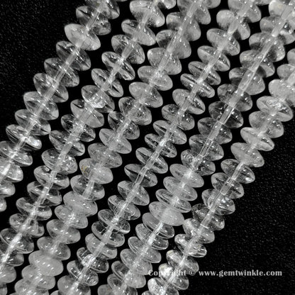 Angled view of clear quartz disc spacer gemstone strands displaying natural internal crack patterns