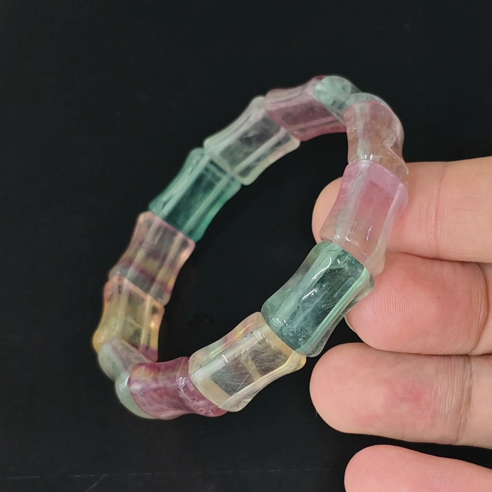 women carved rainbow fluorite bamboo joint segment stretch bracelet held in hand