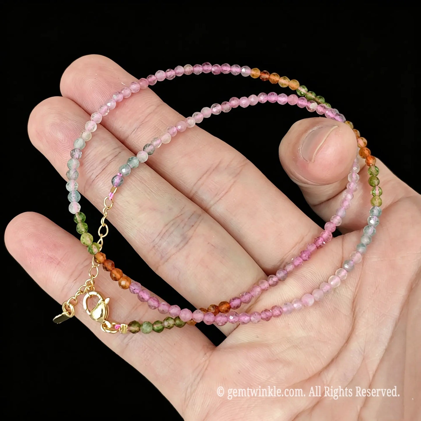 faceted rainbow tourmaline micro bead necklace loop with gold tone extender chain in hand