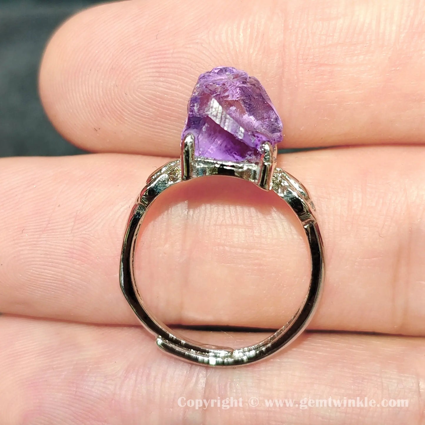 Close up view of metal alloy prong set unpolished raw purple amethyst nugget on adjustable ring