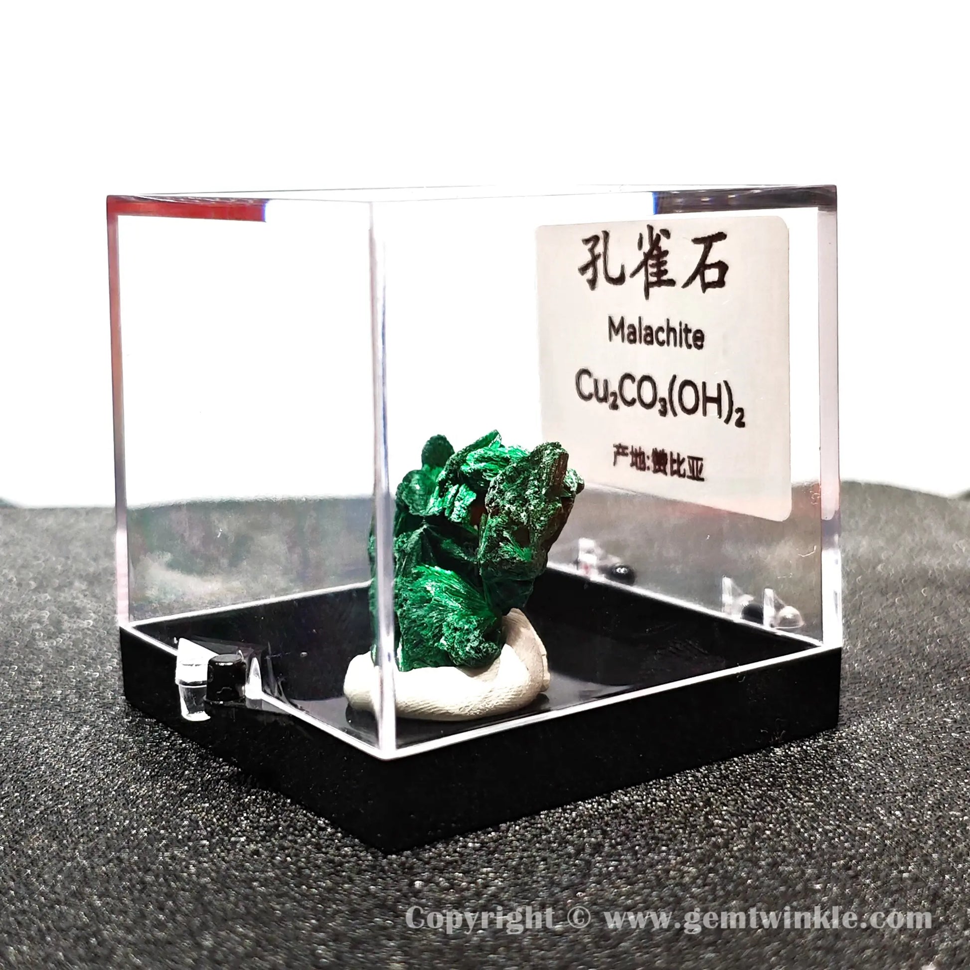 Angled left perspective showing clear acrylic housing and vivid green malachite fibrous cluster