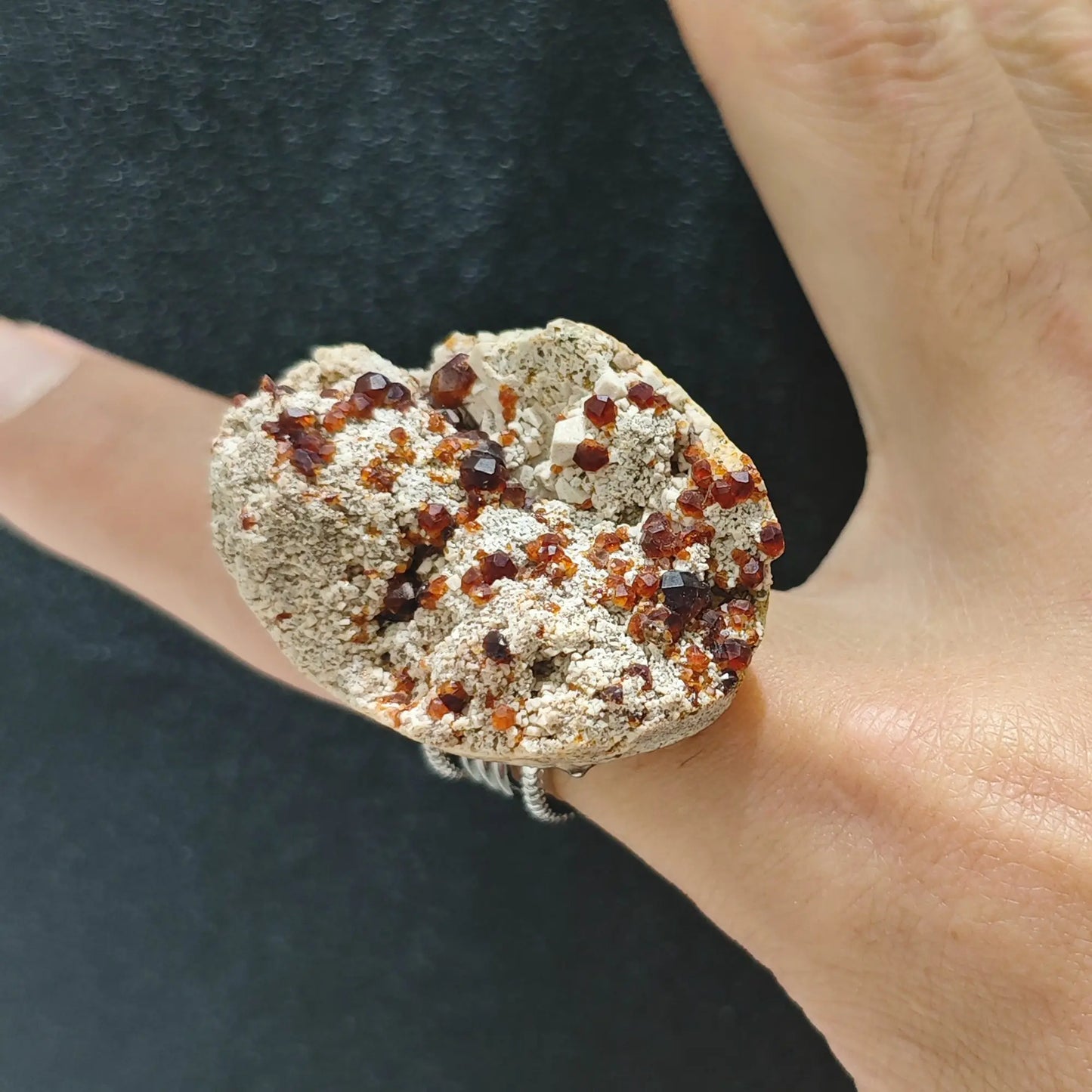 Raw garnet crystal matrix slice adjustable alloy ring worn on hand showing deep red crystals on earthy matrix