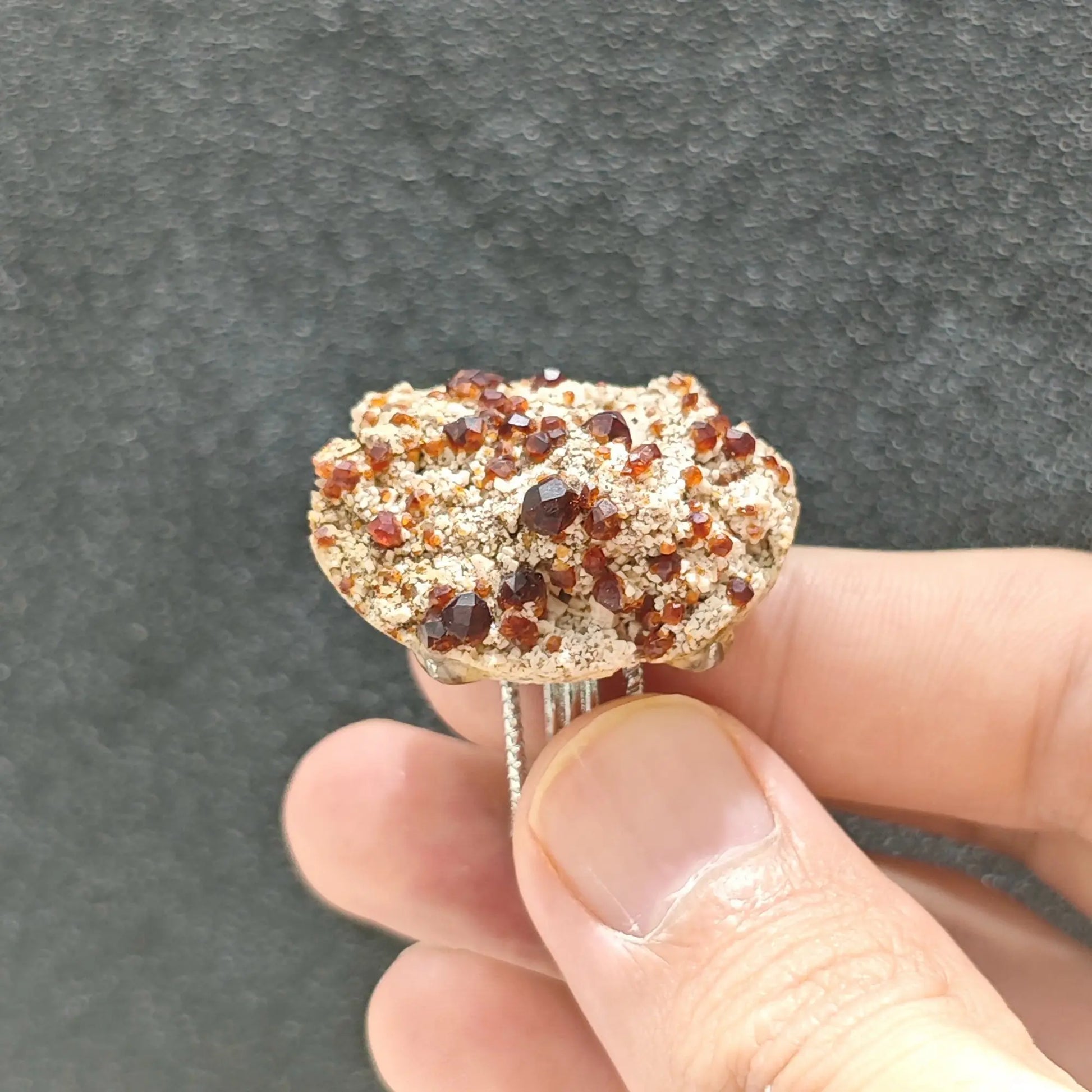 Raw garnet mineral slice ring showcasing the textured multi strand adjustable alloy ring band and stone underside