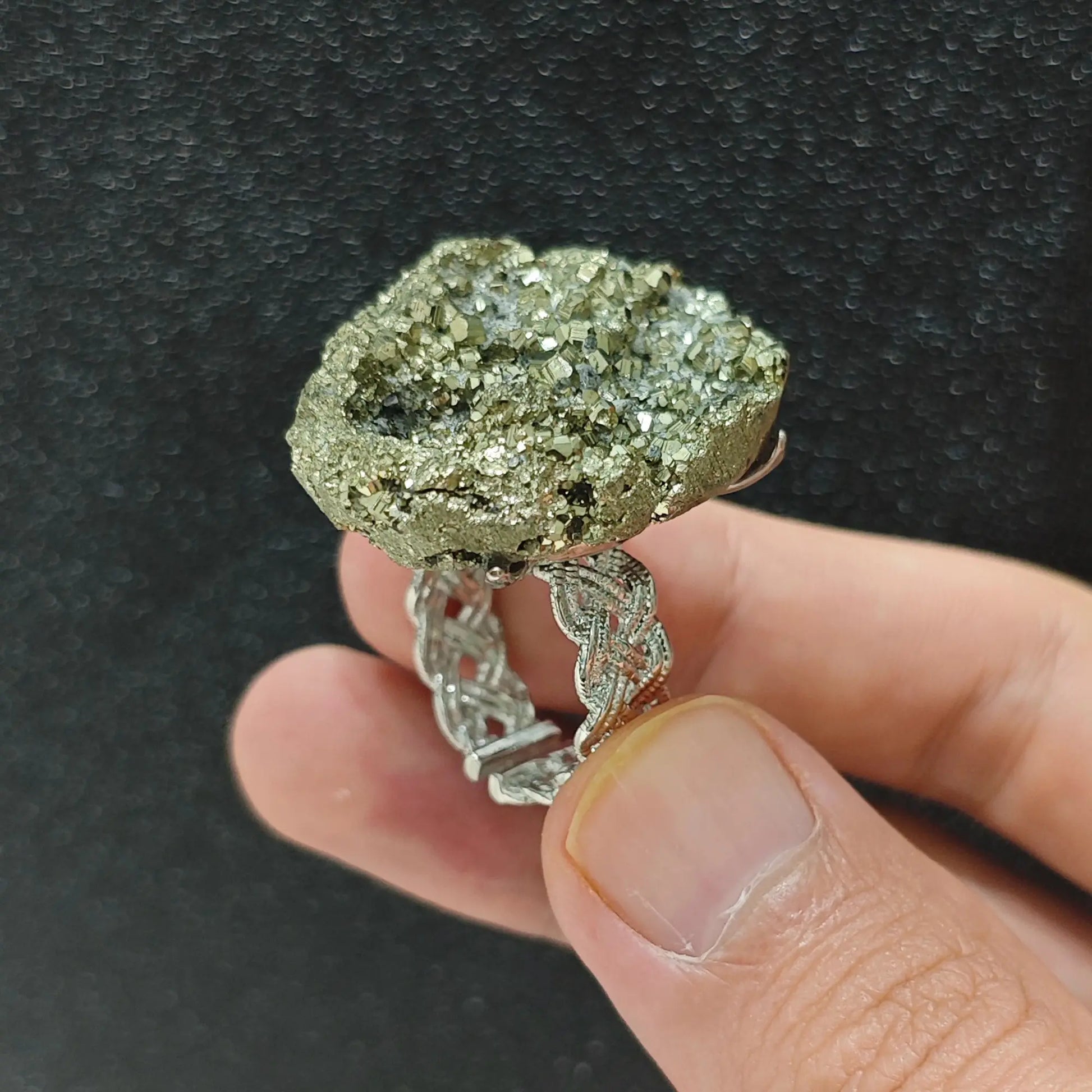 Raw pyrite crystal cluster adjustable alloy ring held in hand showing metallic gold mineral points and alloy band