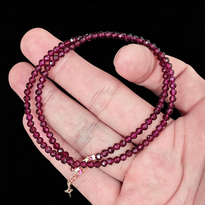 3-4mm red garnet faceted bead strand held in hand showing deep wine red clarity