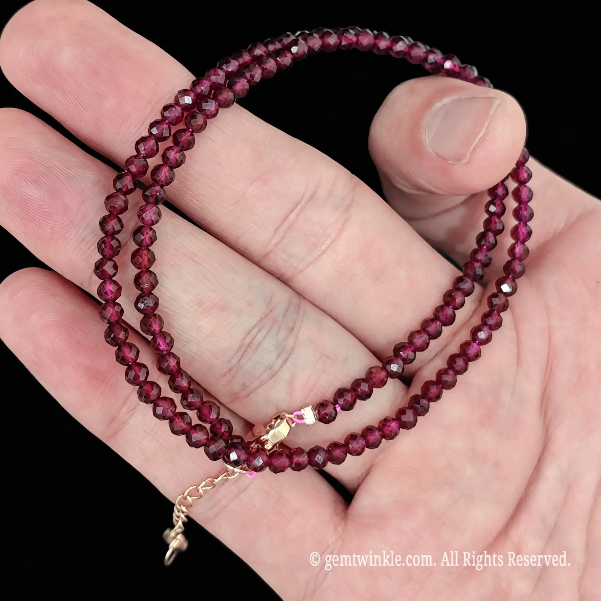 detail view of gold tone alloy clasp and 5cm extender chain on garnet bead necklace