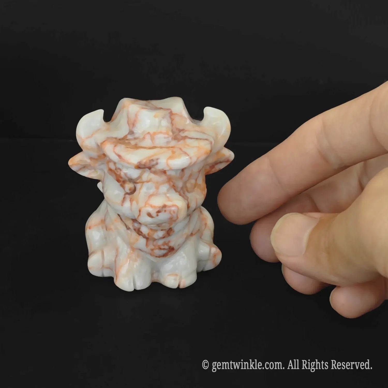 Hand carved red zebra striped stone cowboy bull figurine showing natural brown line textures