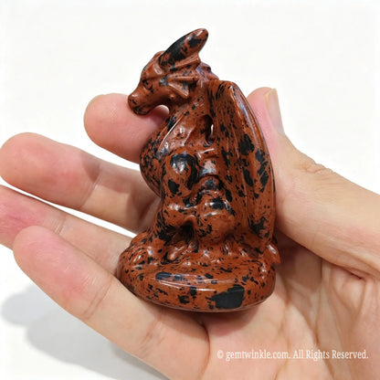 Single red mahogany obsidian dragon statue 7cm height held in hand displaying polished wing and body contours
