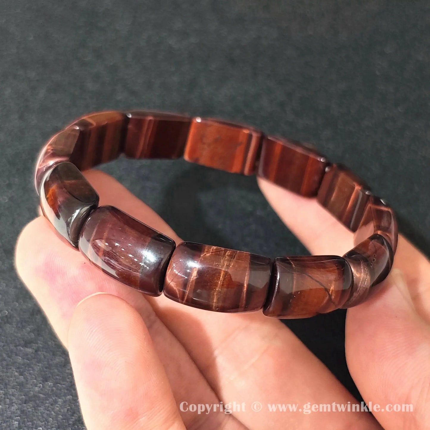 side profile view of machine polished red tigers eye curved plate cuff bracelet
