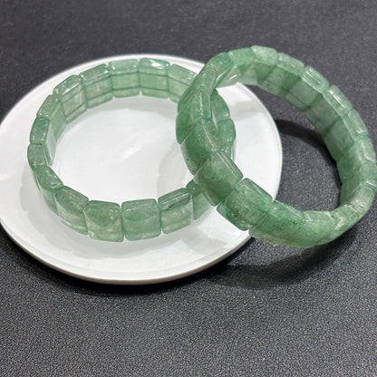 Overhead view: natural green strawberry quartz square bead bracelet; consistent width, no metal, elastic cord hidden for seamless elegance