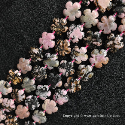 Angled view of natural pink rhodonite floral carved gemstone strands