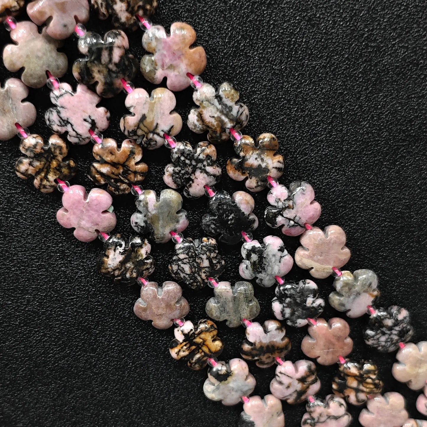 Macro closeup of rhodonite plum blossom carved beads 15mm showing natural black matrix