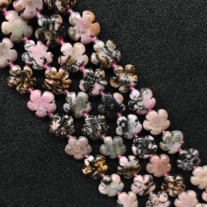 Macro closeup of rhodonite plum blossom carved beads 15mm showing natural black matrix