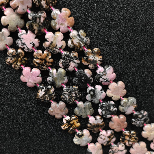 Macro closeup of rhodonite plum blossom carved beads 15mm showing natural black matrix