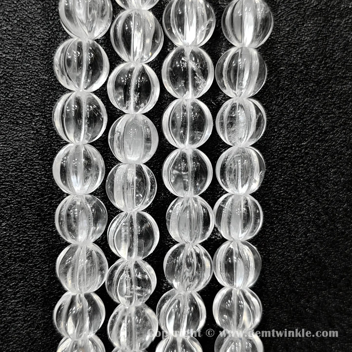 Vertical alignment of clear quartz carved pumpkin beads highlighting fluted ridges