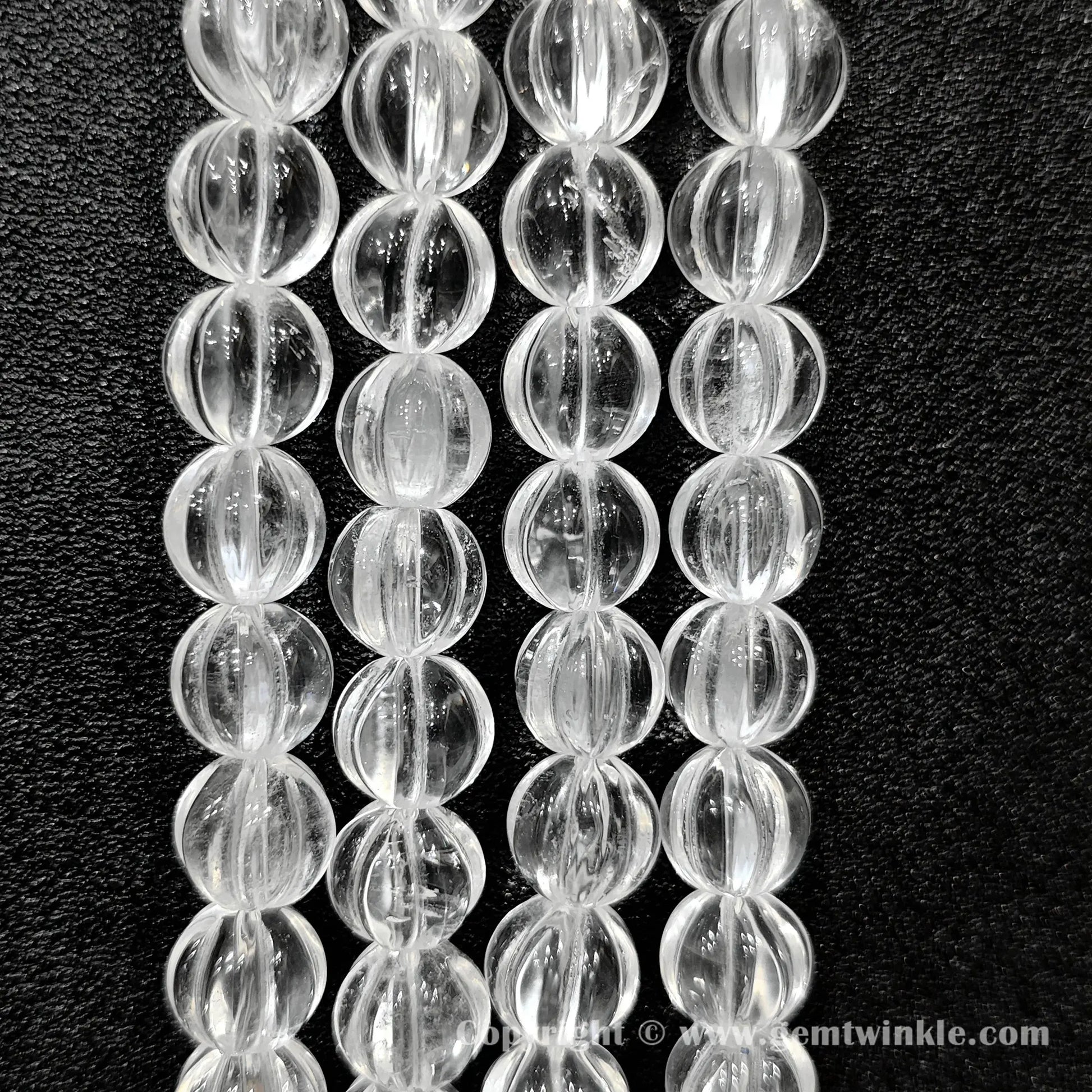 Vertical alignment of clear quartz carved pumpkin beads highlighting fluted ridges