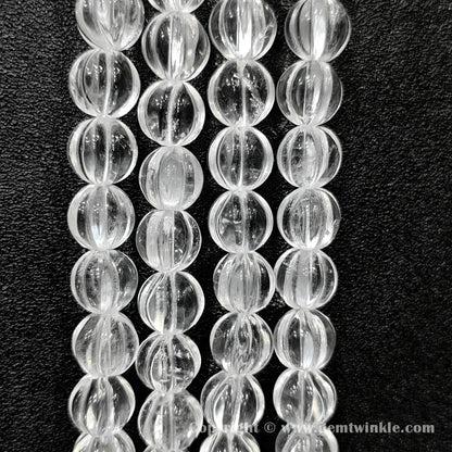 Vertical alignment of clear quartz carved pumpkin beads highlighting fluted ridges