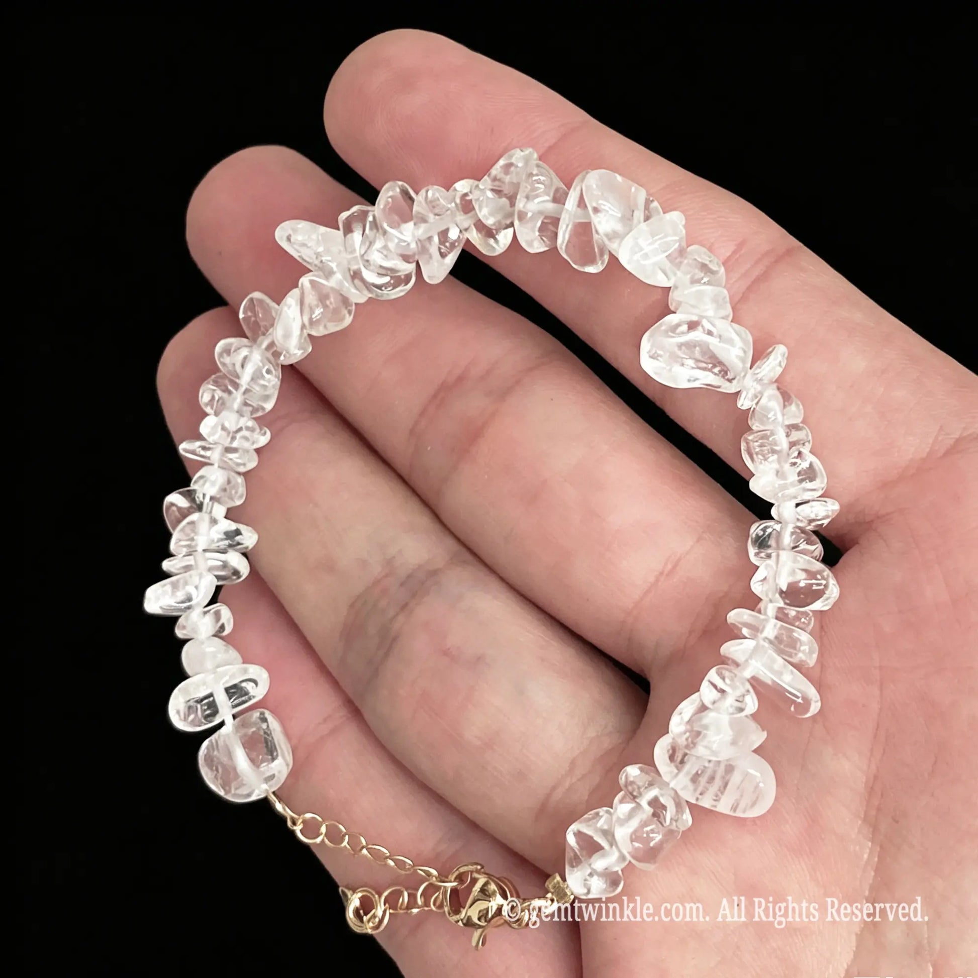 rock crystal chip bracelet laid across palm displaying translucent bead structure