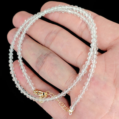 faceted clear quartz micro bead necklace loop with gold tone extender chain in hand