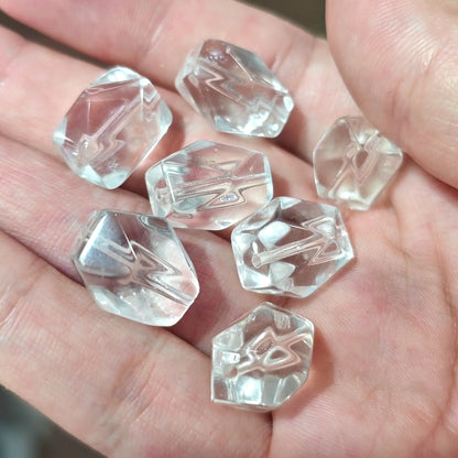Close up view of natural rock crystal freeform beads in hand showcasing subtle wispy inclusions