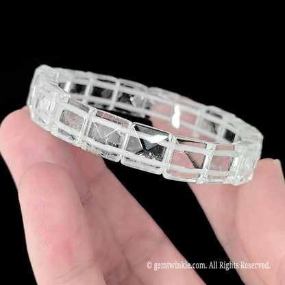 Rock crystal pyramid cut square bead stretch bracelet held showing clear transparent matrix and natural ice veils