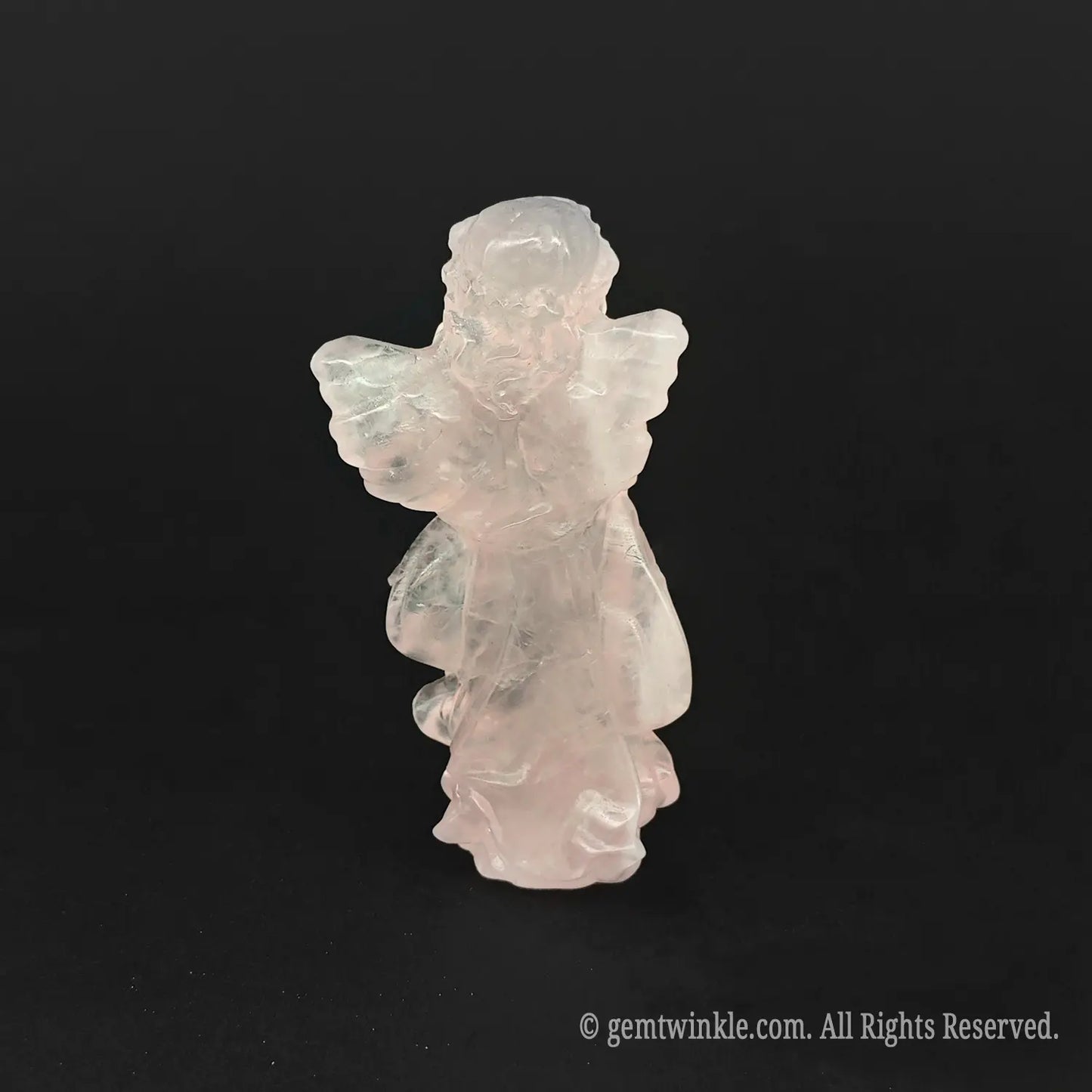 Back view of a natural rose quartz praying angel carving displaying its glossy polished wing detailing, perfect as soft crystal gifts for her