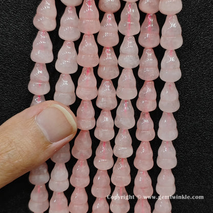 Close up view of natural rose quartz calabash beads held on fingers for quality preview