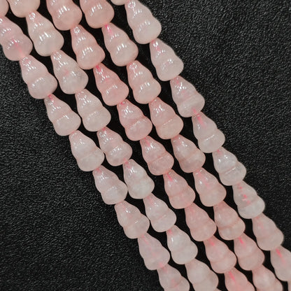 Macro closeup of natural pink rose quartz gourd beads showing smooth polish and calabash shape