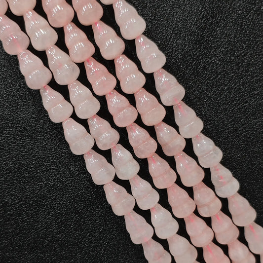 Macro closeup of natural pink rose quartz gourd beads showing smooth polish and calabash shape