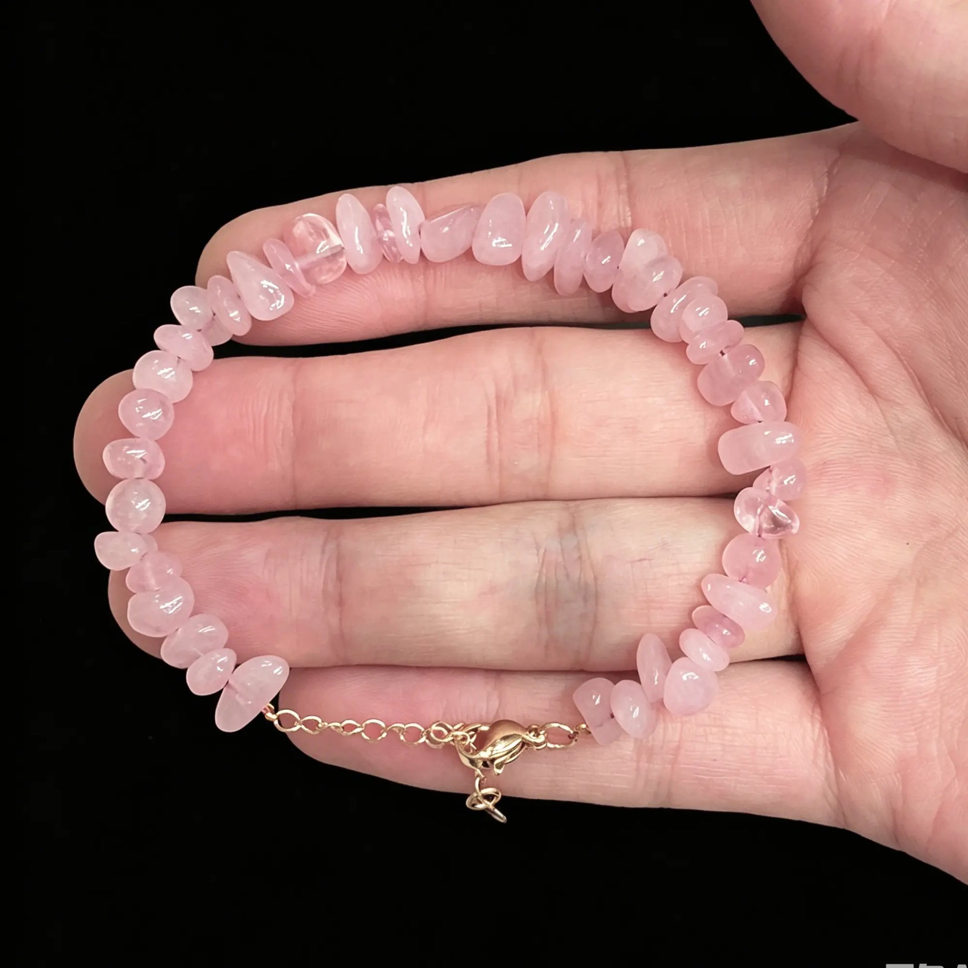 rose quartz chip bracelet held on hand displaying natural pink color