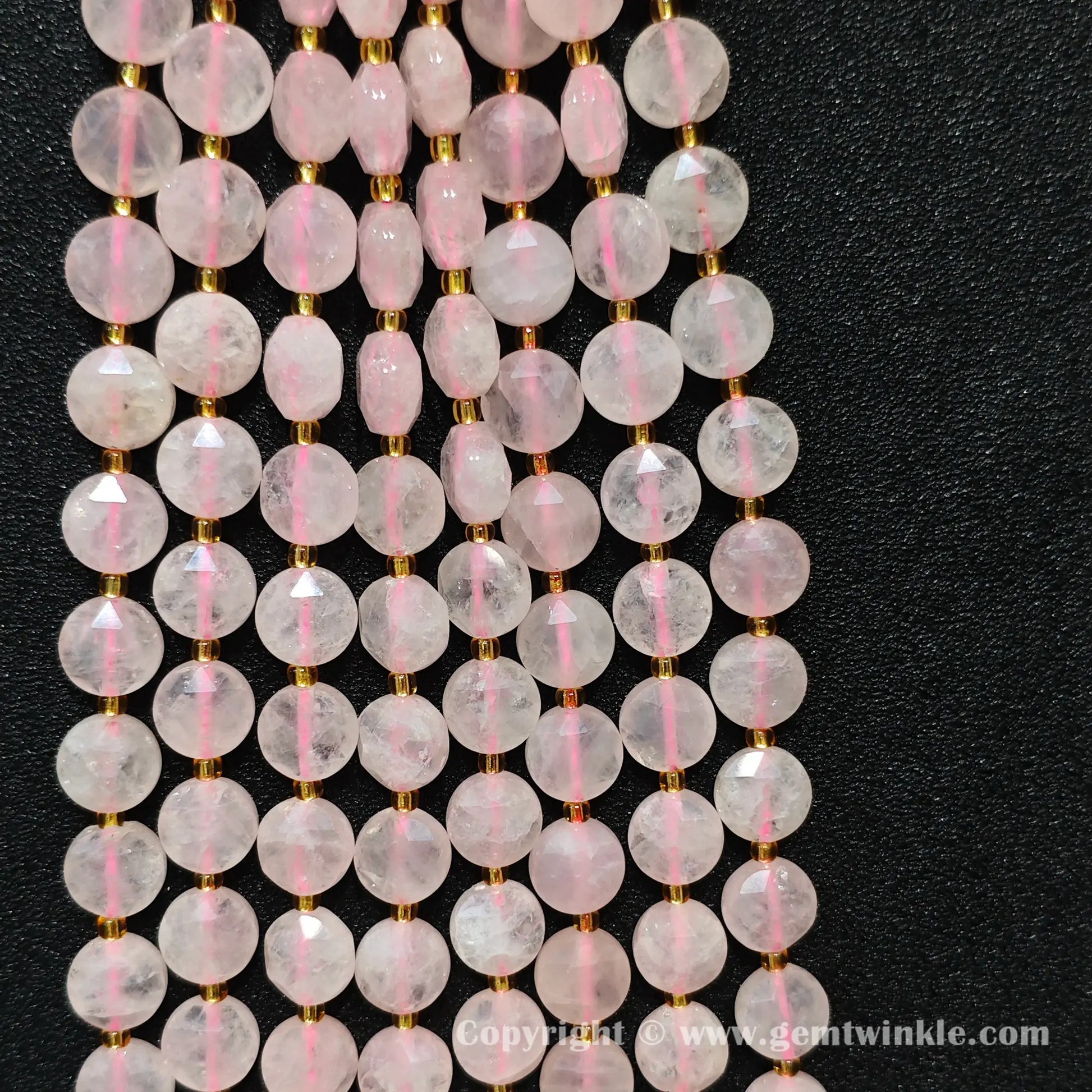 Hand holding strands of 10mm rose quartz hexagram flat disc beads with approx 30 beads