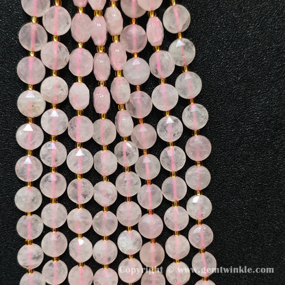 Hand holding strands of 10mm rose quartz hexagram flat disc beads with approx 30 beads