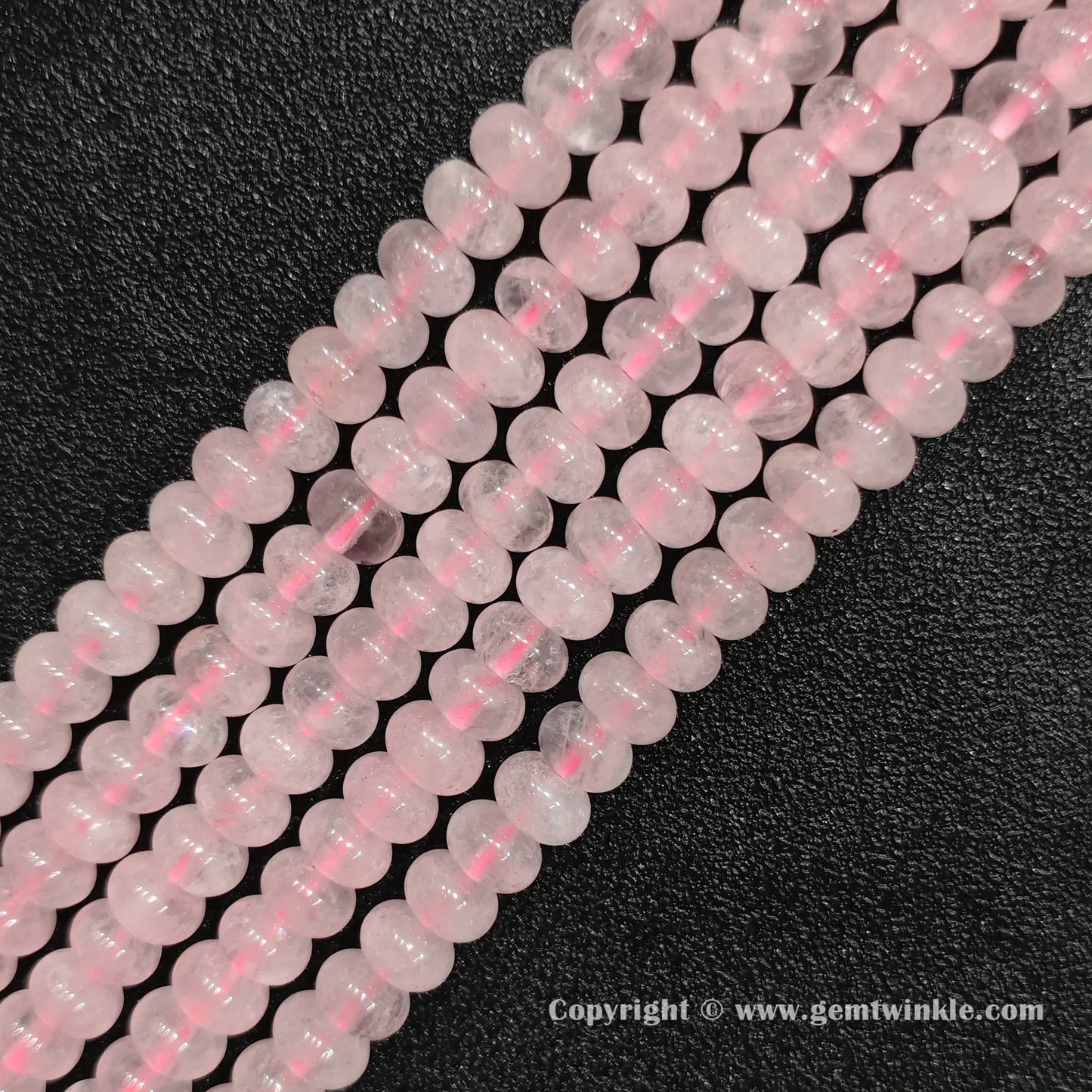 Perspective view of rose quartz smooth heishi spacer beads showing uniform 6mm disc thickness