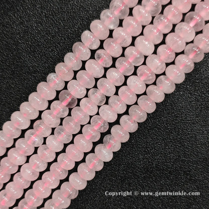 Perspective view of rose quartz smooth heishi spacer beads showing uniform 6mm disc thickness