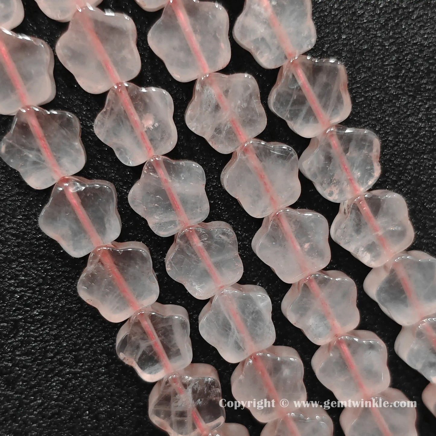 Natural rose quartz star bead strand held over hand for size scale
