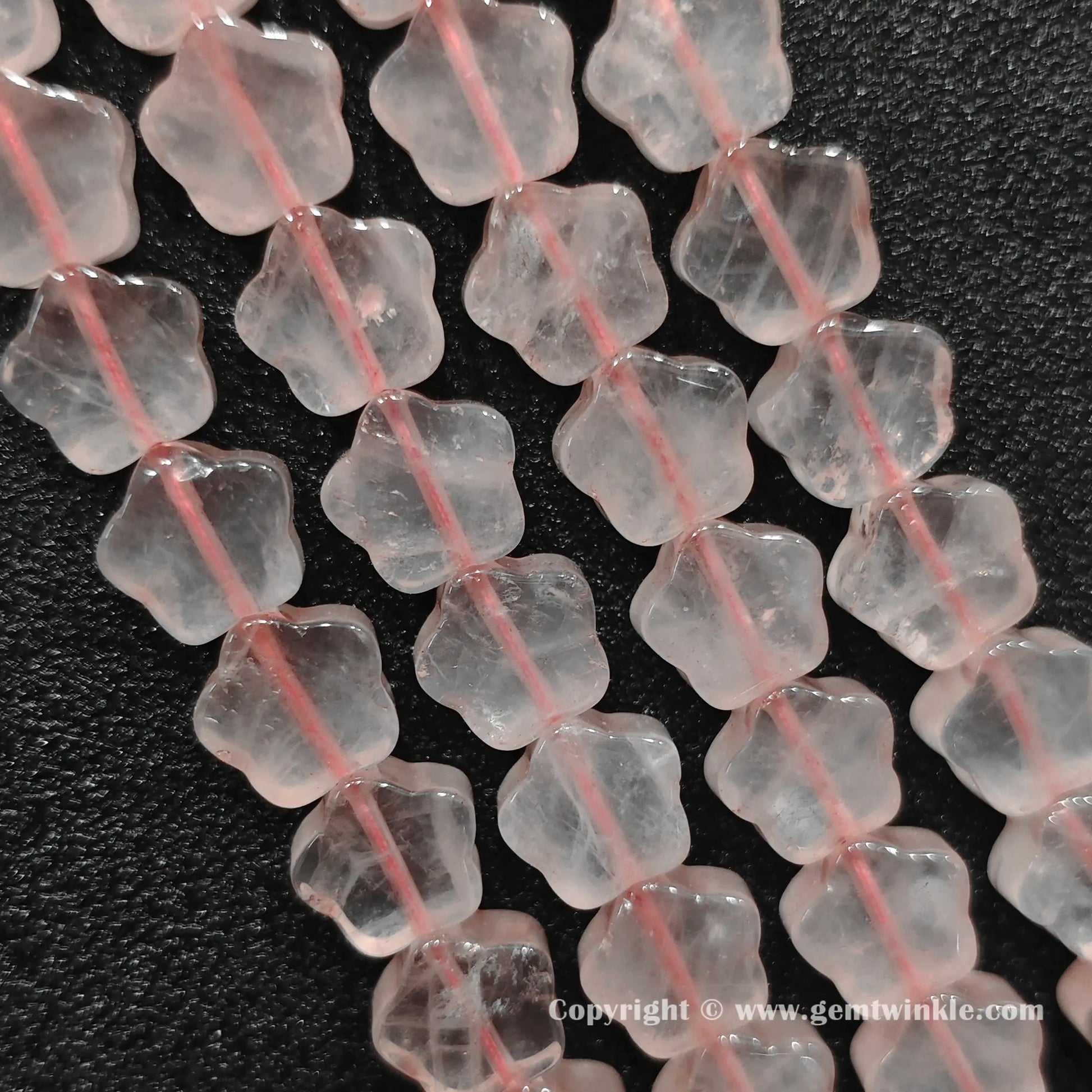 Natural rose quartz star bead strand held over hand for size scale