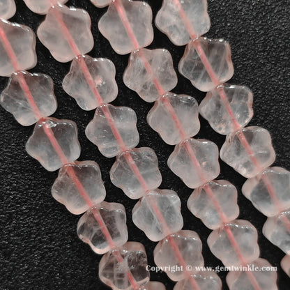 Natural rose quartz star bead strand held over hand for size scale