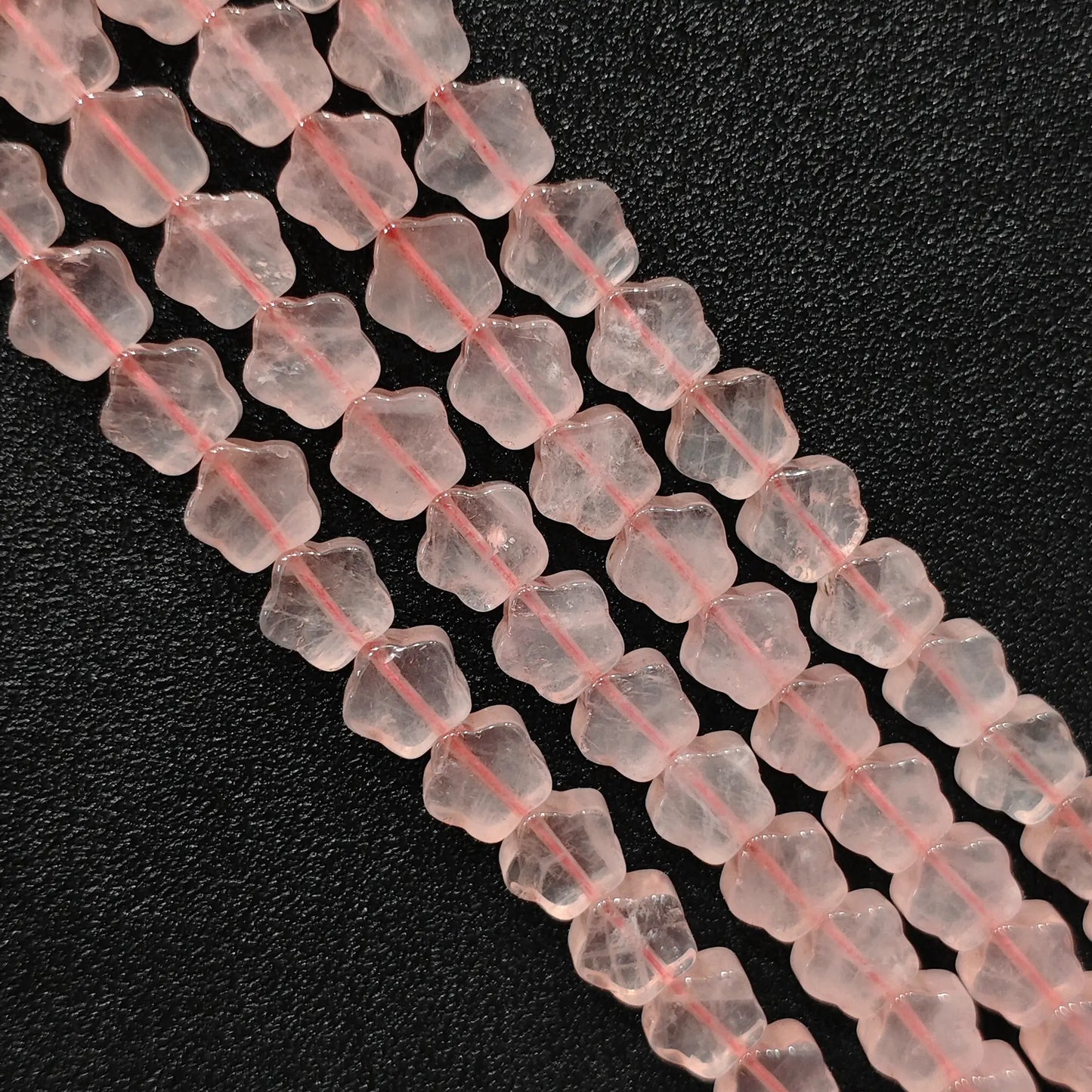 Macro closeup of natural pink rose quartz star carved beads showing smooth polish