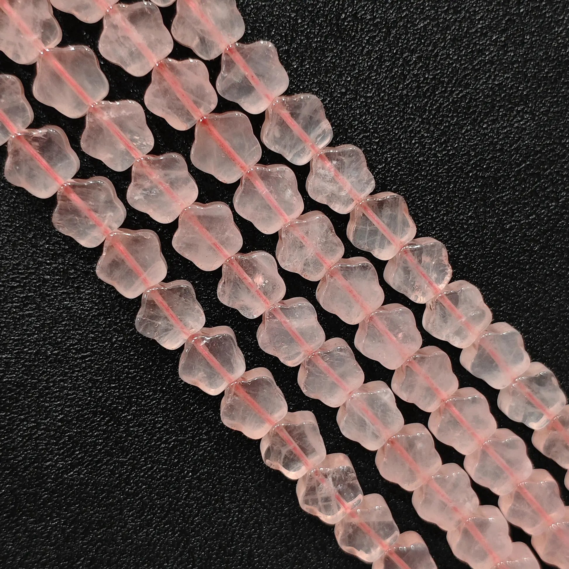 Macro closeup of natural pink rose quartz star carved beads showing smooth polish
