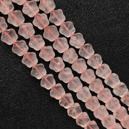 Macro closeup of natural pink rose quartz star carved beads showing smooth polish