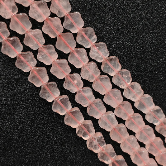 Macro closeup of natural pink rose quartz star carved beads showing smooth polish