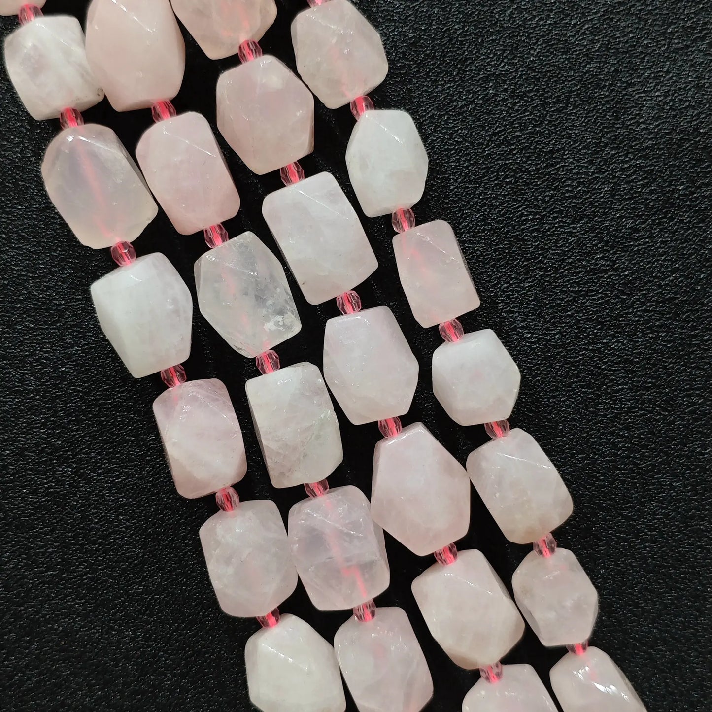 close up view of translucent pastel pink quartz geometric cylinder beads