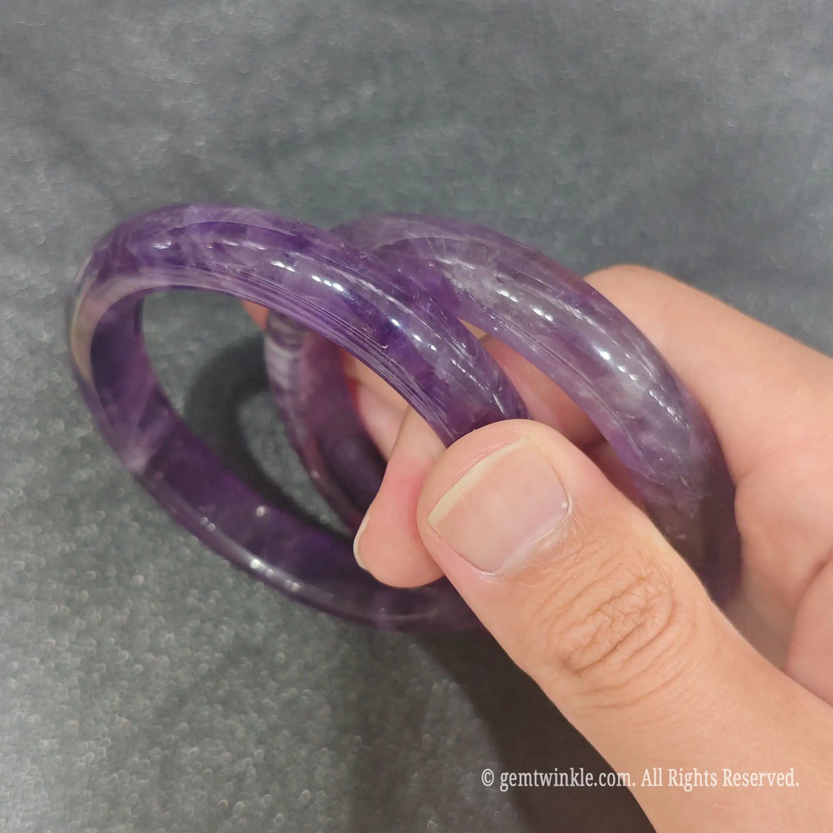 Side profile of smooth polished Amethyst quartz bangle bracelets showcasing solid stone thickness