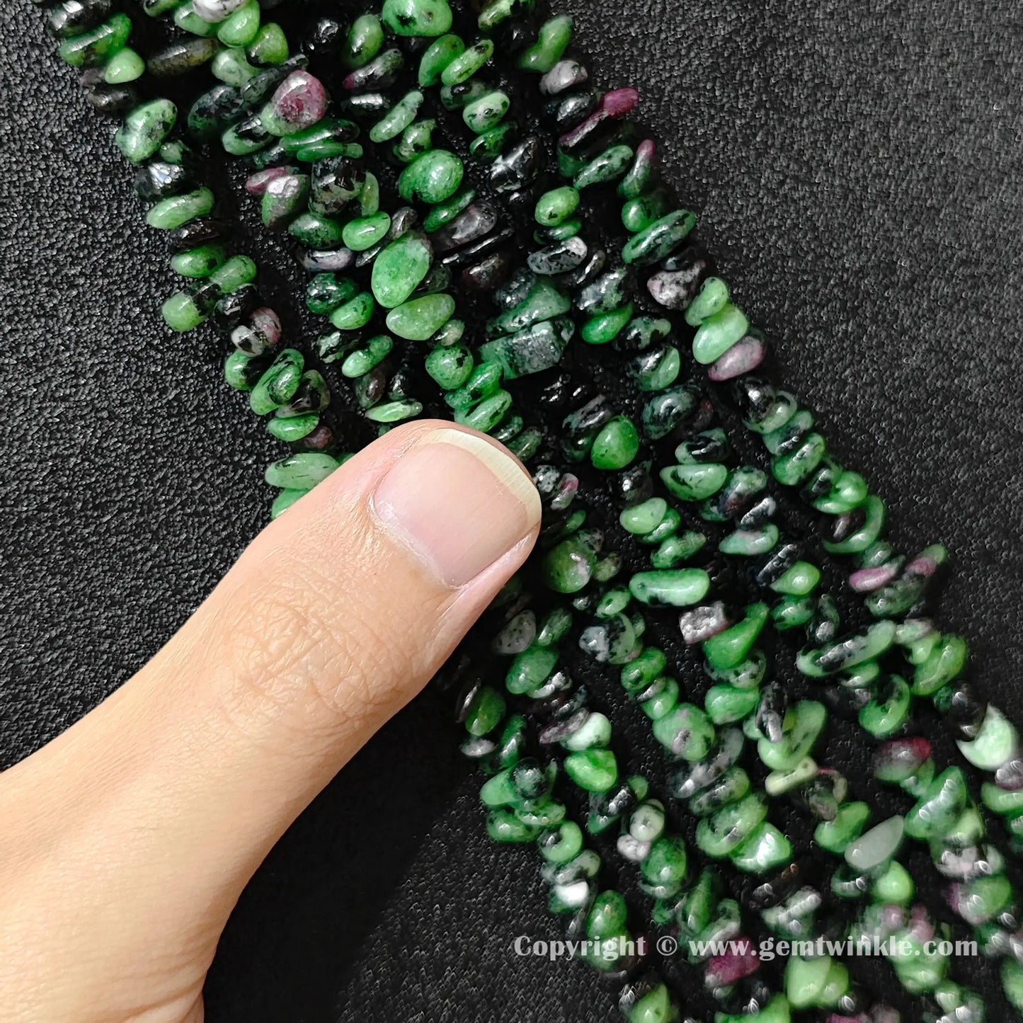 Natural ruby zoisite chip bead strand held over hand showing 80cm strand scale