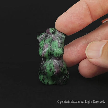 Handheld view of a 4cm natural Ruby Zoisite pregnant goddess torso carving demonstrating real tactile size for crystal shop buyers.
